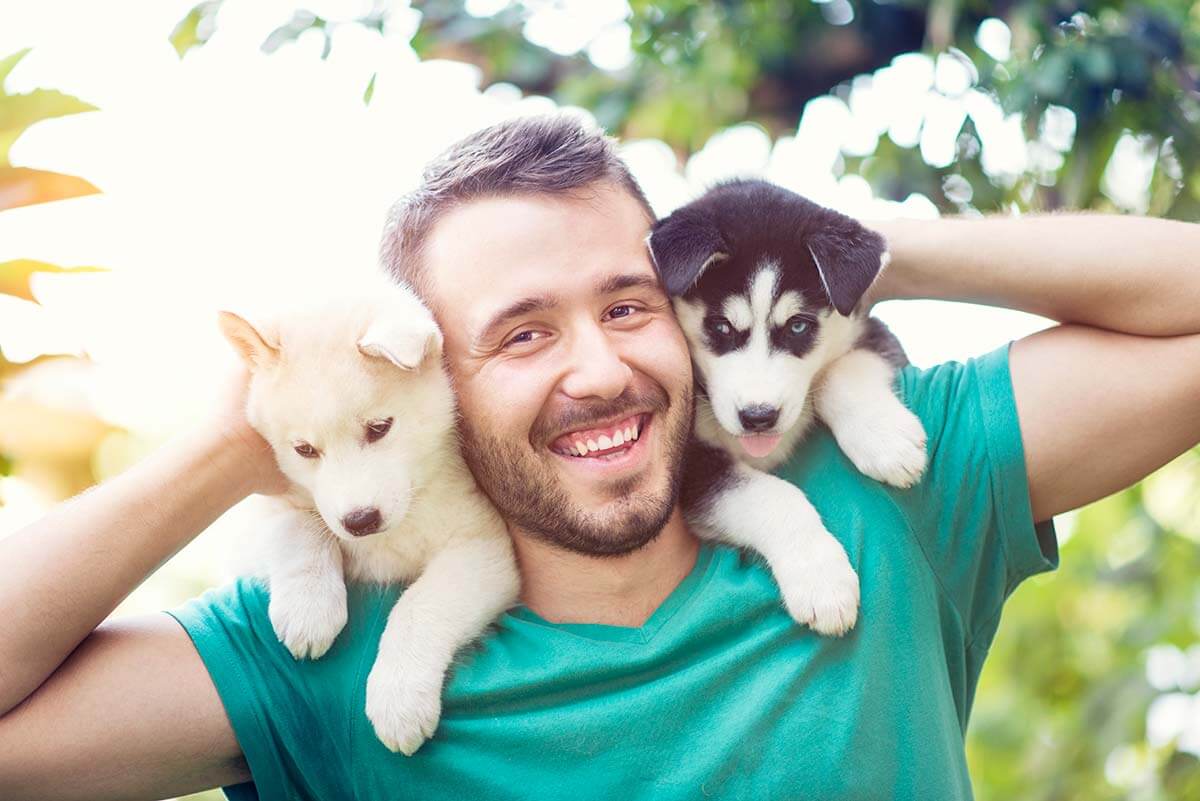 man with two puppies